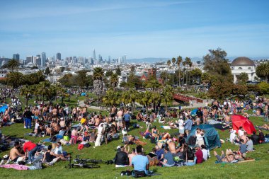 San Francisco, California - 25 Nisan 2023: İnsanlar mavi gökyüzüne karşı ilkbahar boyunca Dolores Park Misyonunda boş vakitlerin tadını çıkarıyorlar