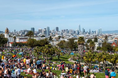San Francisco, California - 25 Nisan 2023: İnsanlar mavi gökyüzüne karşı ilkbahar boyunca Dolores Park Misyonunda boş vakitlerin tadını çıkarıyorlar