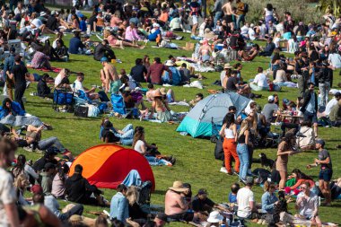 San Francisco, California - 25 Nisan 2023: İnsanlar mavi gökyüzüne karşı ilkbahar boyunca Dolores Park Misyonunda boş vakitlerin tadını çıkarıyorlar