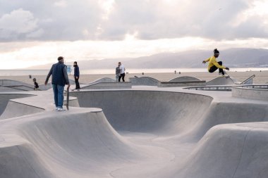 Venice Beach, California, ABD - 5 Mayıs 2023: İnsanlar Venedik Plajı 'nda gün batımında paten kayıyorlar, LA, California