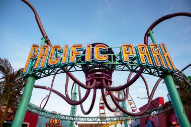 Santa Monica, California - Mayıs 07, 2023. Atlıkarınca ve hız treniyle Pasifik Parkı girişinde Santa Monicas, Los Angeles, Kaliforniya 'daki lunaparkta. 