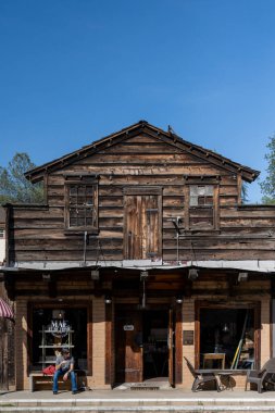 Mariposa, ABD - 04, 28, 2023: Ana caddedeki iki katlı tarihi bina ve tüm yerel ve sanatsal ürünler mavi bulutsuz gökyüzü altında.