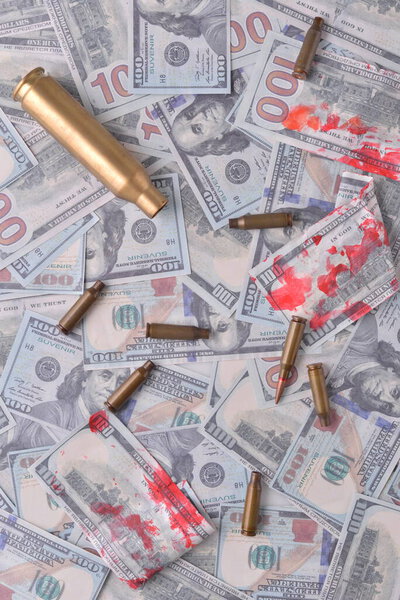 blood money of war. Cartridges with blood in dollar bills.
