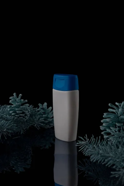 松のクリスマスシャンプー 黒の背景にトウヒとコーンの白いシャンプーボトル — ストック写真