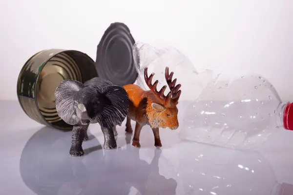plastic pollution concept harm to animals. Animal toys with plastic, metal and glass on a white background installation.