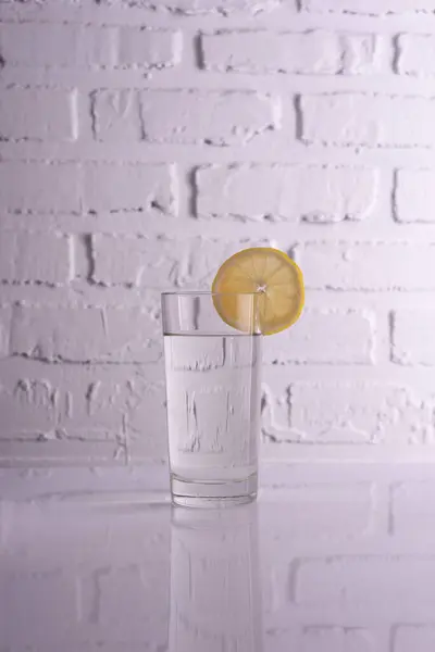 glass of water with lemon on a white background.
