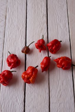 Beyaz ahşap arka planda canlı acı biber.