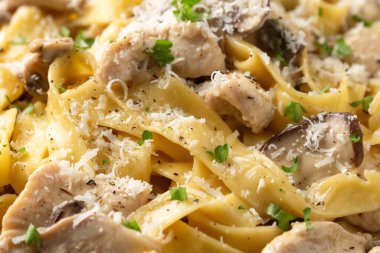 Tavuk, mantar ve parmesan peynirli kremalı Alfredo makarnası. Sağlıklı İtalyan yemekleri.