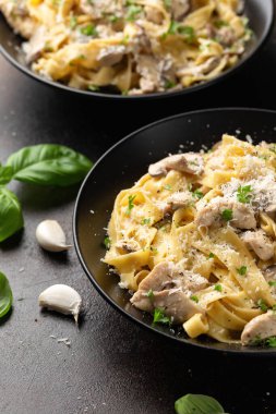 Tavuk, mantar ve parmesan peynirli kremalı Alfredo makarnası. Sağlıklı İtalyan yemekleri.