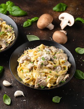 Tavuk, mantar ve parmesan peynirli kremalı Alfredo makarnası. Sağlıklı İtalyan yemekleri.