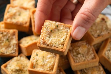 Maydanozlu ekmek kırıntısıyla kaplı kremalı soslu morina ve somonla dolu mini balık turtaları..