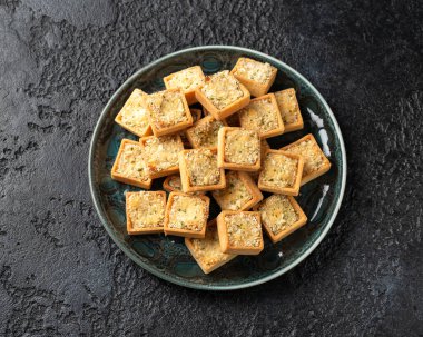 Maydanozlu ekmek kırıntısıyla kaplı kremalı soslu morina ve somonla dolu mini balık turtaları..