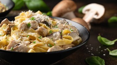 Tavuk, mantar ve parmesan peynirli kremalı Alfredo makarnası. Sağlıklı İtalyan yemekleri.