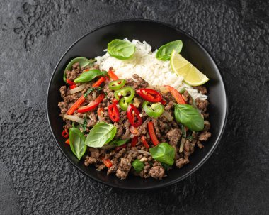 Kızarmış Pad Kra Pao 'yu siyah kasede pilavla karıştır..