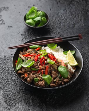 Kızarmış Pad Kra Pao 'yu siyah kasede pilavla karıştır..