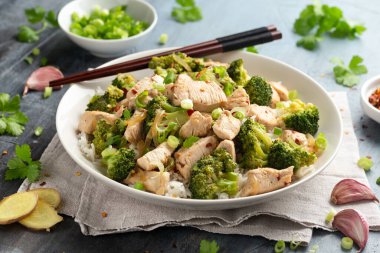 Kızarmış tavuk ve brokoli ile pilavı beyaz tabakta karıştır..