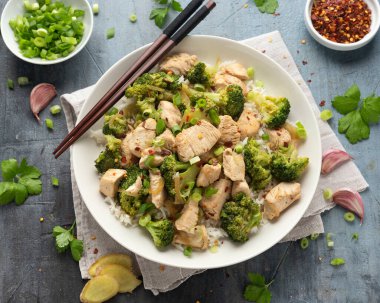 Kızarmış tavuk ve brokoli ile pilavı beyaz tabakta karıştır..