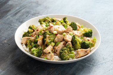 Kızarmış tavuk ve brokoli ile pilavı beyaz tabakta karıştır..