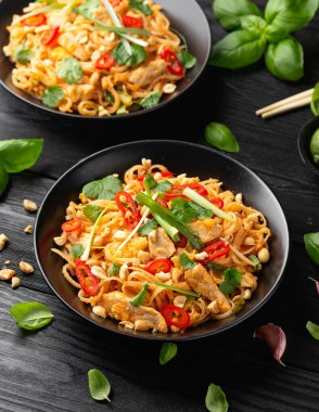 Yumurtalı Pad Thai tavuğu, fasulye filizi, fıstık ve taze soğan..