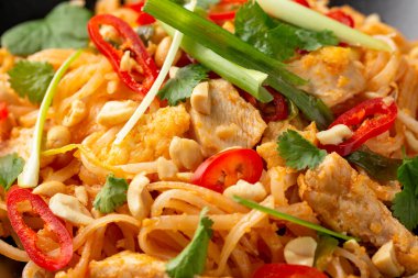 Yumurtalı Pad Thai tavuğu, fasulye filizi, fıstık ve taze soğan..