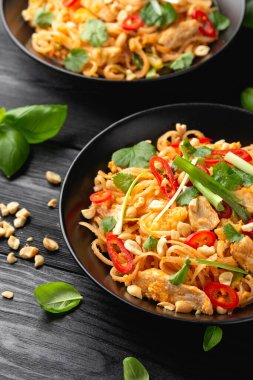 Yumurtalı Pad Thai tavuğu, fasulye filizi, fıstık ve taze soğan..