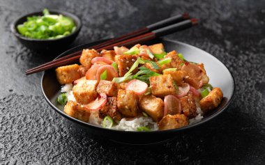 Turplu kızarmış tofu, taze soğan ve sarımsak, siyah kasede zencefil sosu..