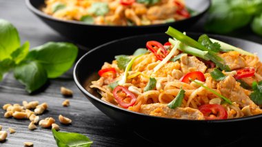Yumurtalı Pad Thai tavuğu, fasulye filizi, fıstık ve taze soğan..