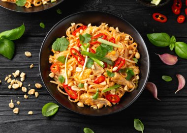 Yumurtalı Pad Thai tavuğu, fasulye filizi, fıstık ve taze soğan..