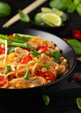 Yumurtalı Pad Thai tavuğu, fasulye filizi, fıstık ve taze soğan..