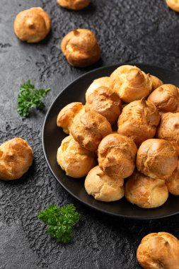 Savoury profiteroles stuffed with Molten cheddar cheese sauce, party food concept.
