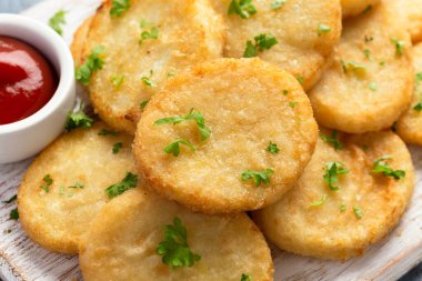Healthy Cauliflower hash browns on white wooden board.