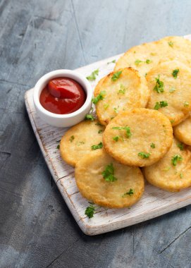 Healthy Cauliflower hash browns on white wooden board.
