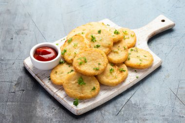 Healthy Cauliflower hash browns on white wooden board.