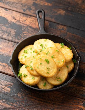Healthy Cauliflower hash browns in cast iron frying pan on rustic wooden table.
