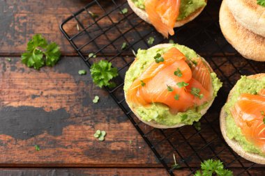 Fresh English Muffins with avocado and salmon. Healthy morning breakfast food.