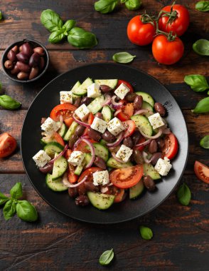 Taze sebzeli Yunan salatası, feta peyniri, kalamata zeytinleri, kurutulmuş kekik, kırmızı şarap sirkesi ve zeytinyağı. Sağlıklı yemek.