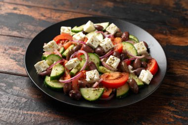 Greek salad with fresh vegetables, feta cheese, kalamata olives, dried oregano, red wine vinegar and olive oil. Healthy food