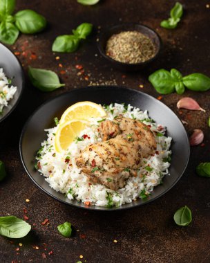 Izgara tavuk butları, siyah kasede pilav ile servis edilir..