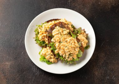 Yeşillikli yumurta salatalı sandviçler ve beyaz tabakta otlar. Sağlıklı yemek.