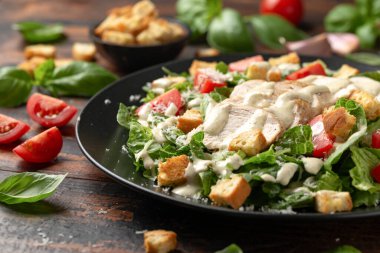 Parmesan peynirli, domatesli, kızarmış tavuk salatası ve sos..