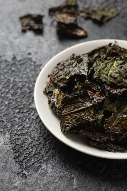 Lezzetli bir Kale cipsi, beyaz tabakta atıştırmalık. Sağlıklı sebze yemeği...