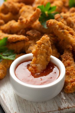 Beyaz tahta üzerinde acı biber soslu kıtır kıtır tavuk..