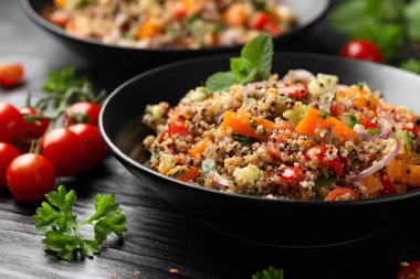 Domatesli, kırmızı ve beyaz kinoa tabbouleh salatası, paprika ve nane. Vejetaryen, vejetaryen gıda konsepti.