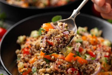 Domatesli, kırmızı ve beyaz kinoa tabbouleh salatası, paprika ve nane. Vejetaryen, vejetaryen gıda konsepti.