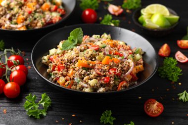 Domatesli, kırmızı ve beyaz kinoa tabbouleh salatası, paprika ve nane. Vejetaryen, vejetaryen gıda konsepti.