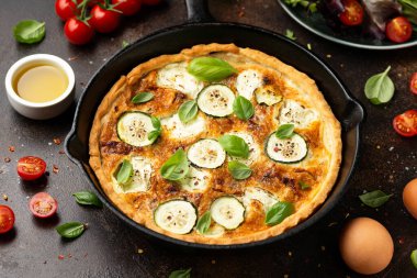 Güneş yanığı domates, keçi peyniri ve yanında salata ile servis edilen dökme demir tavada kabak kiş..