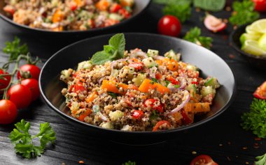Domatesli, kırmızı ve beyaz kinoa tabbouleh salatası, paprika ve nane. Vejetaryen, vejetaryen gıda konsepti.