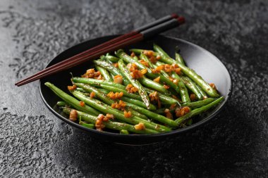 Kızarmış sarımsak, siyah kasede zencefilli yeşil fasulye..