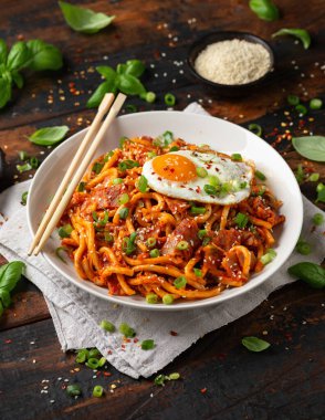 Kızarmış yumurta ve pastırmalı Kimchi Udon Noodle. Kore yemeği.