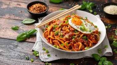 Kızarmış yumurta ve pastırmalı Kimchi Udon Noodle. Kore yemeği.